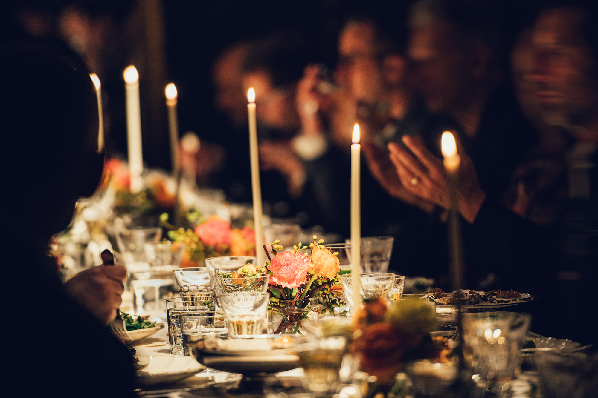 People enjoy a family dinner with candles. Big table served with